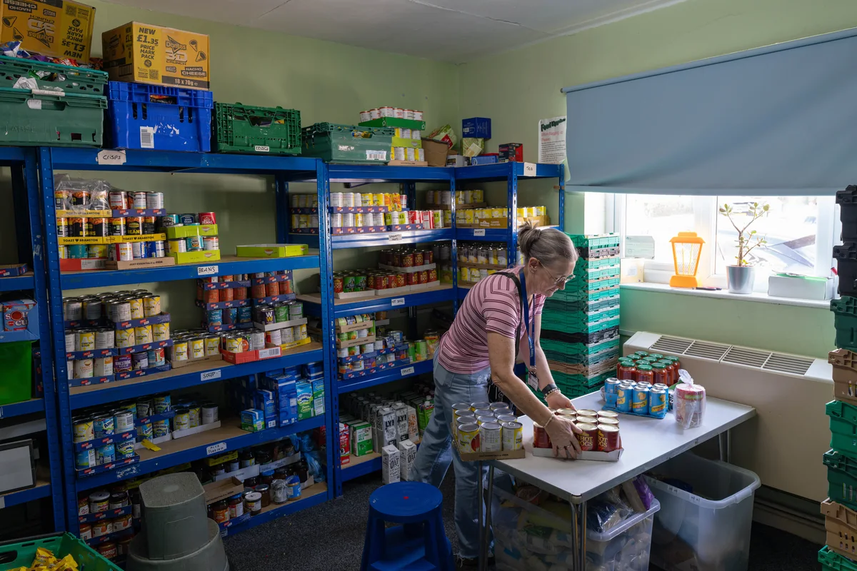Trinity Mission volunteer organizing pantry shelves and food packages in the food bank